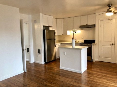 an empty kitchen with a stainless steel refrigerator